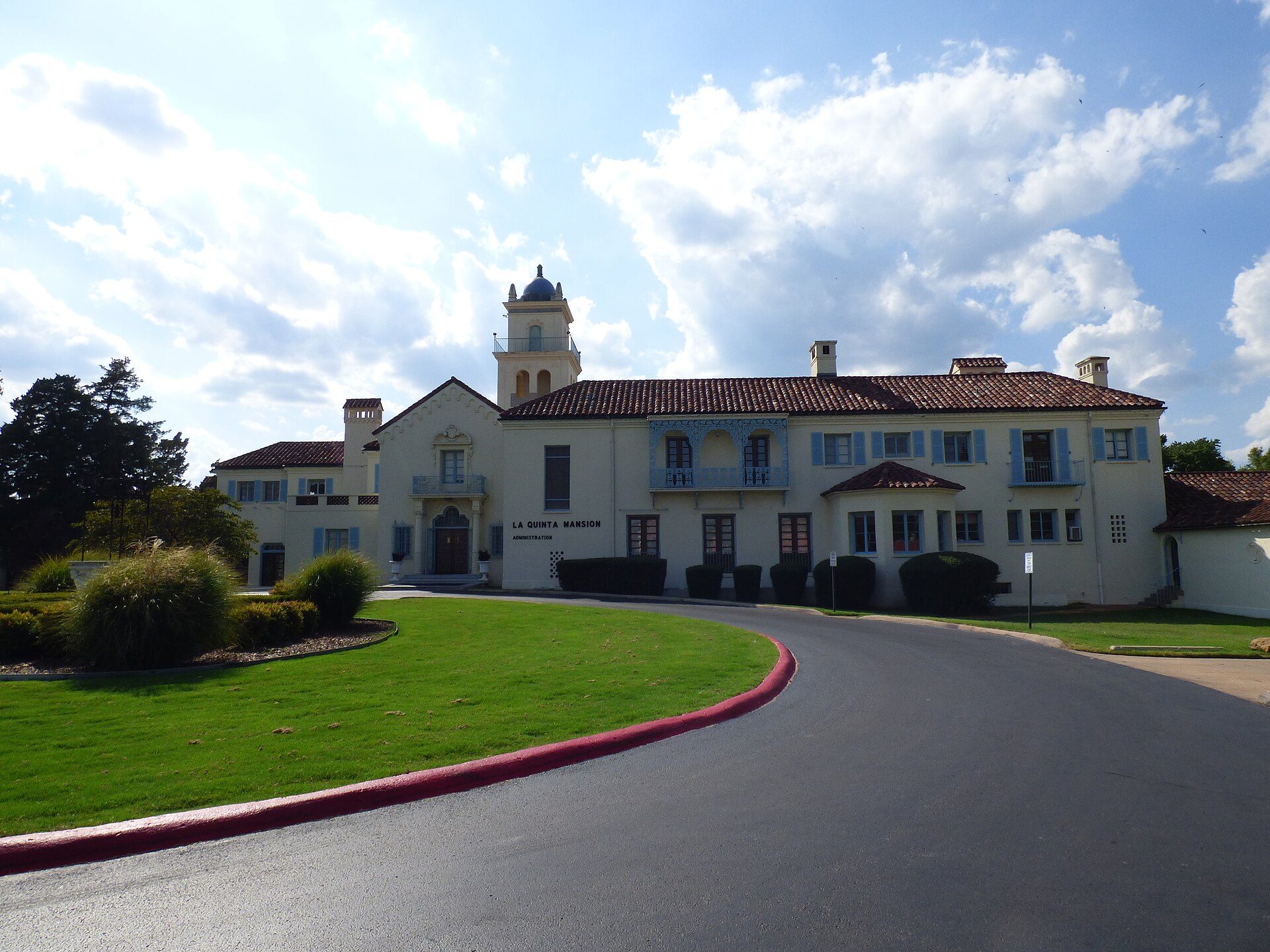 A large, elegant hotel with a central courtyard, featuring multiple rooms and a scenic view.